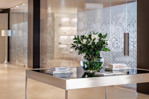a glass table with a vase with a plant on it at AC Hotel San Sebastián de los Reyes by Marriott in San Sebastián de los Reyes