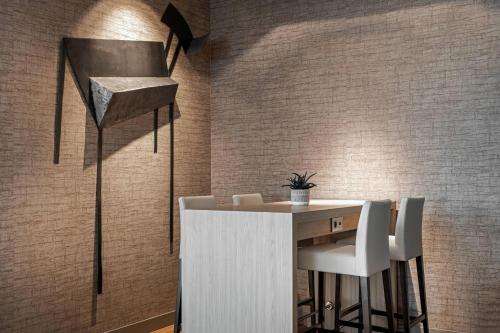 a bar with white chairs and a table in a room at AC Hotel San Sebastián de los Reyes by Marriott in San Sebastián de los Reyes
