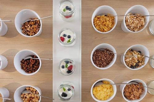 a group of bowls filled with different types of food at AC Hotel San Sebastián de los Reyes by Marriott in San Sebastián de los Reyes