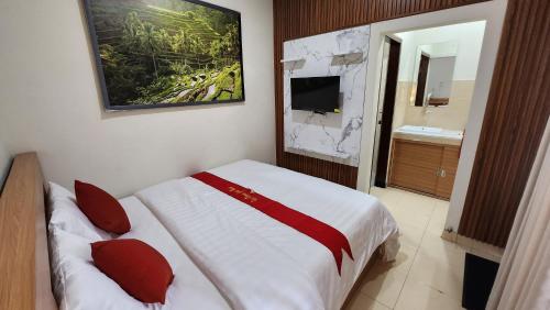 a hotel room with a bed and a bathroom at Puri Rama Guest House Denpasar Bali in Kerobokan