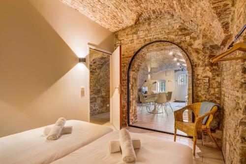 a bedroom with two beds in a room with a stone wall at Luxurious canal apartment in Utrecht A Location in Utrecht