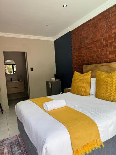 a bedroom with a large bed with yellow pillows at Purple Steps Guest House in Kimberley