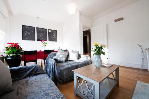 a living room with two couches and a table at Harrods Flats in London