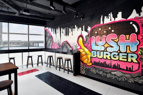 a bar with a wall covered in graffiti at JW Marriott Marquis Hotel Dubai in Dubai