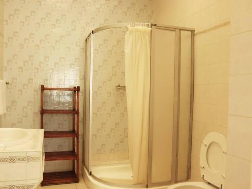 a bathroom with a shower with a toilet and a sink at The Landmark Boutique Hotel in Blantyre