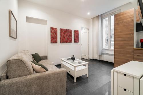 una sala de estar con un sofá y una mesa en Appartement cosy à 2 min de Paris 16 ème, en Boulogne-Billancourt