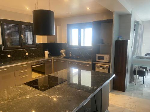 La cuisine est équipée d'un comptoir en granit et d'un réfrigérateur. dans l'établissement Logement fenay 15 minutes de Dijon, à Fénay