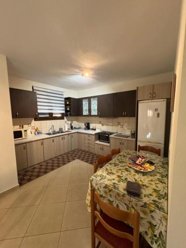 a kitchen with a table and a white refrigerator at Evan's House in Tríkala