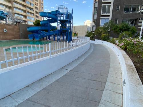 a water slide in a park next to a pool at Bello Dpto central a pasos de la Quinta Vergara, Mall, Plaza de Viña, con estacionamiento, ideal para recorrer la ciudad caminando relajado in Viña del Mar