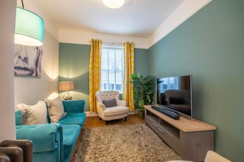 a living room with a blue couch and a tv at Walmgate Cottage in York