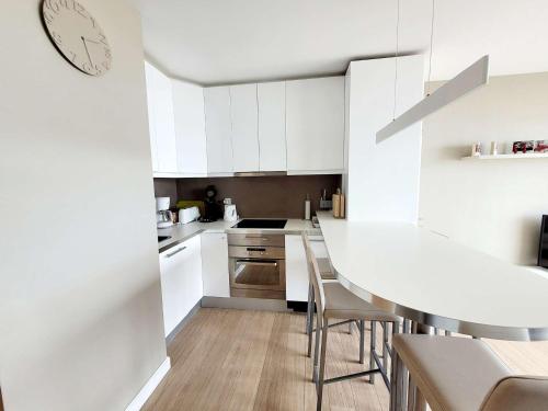 une cuisine avec des armoires blanches et une table et des chaises dans l'établissement T2 Cabine avec Balcon et WIFI sur la Digue de Wimereux - FR-1-675-39, à Wimereux