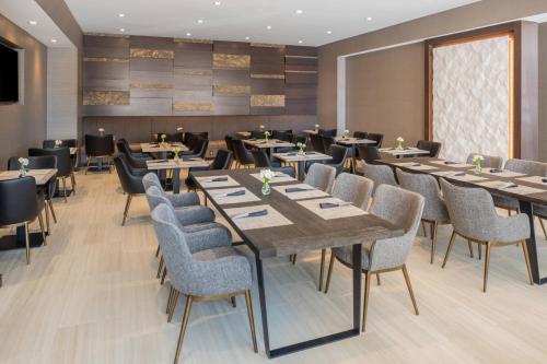 a dining room with wooden tables and chairs at AC Hotel by Marriott Worcester in Worcester