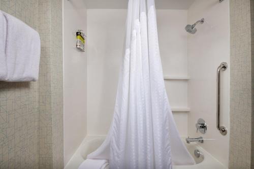 a bathroom with a shower with a white shower curtain at Holiday Inn Express - Lockport by IHG in Lockport