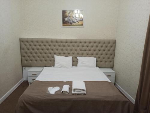a bedroom with a large bed with shoes on it at Sahil Boutique Hotel in Baku