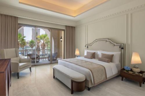 a bedroom with a large bed and a balcony at The St. Regis Marsa Arabia Island, The Pearl Qatar in Doha
