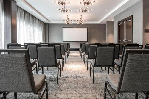a conference room with chairs and a projection screen at AC Hotel by Marriott Boston Downtown in Boston