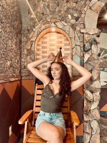 a woman sitting on a chair with a party hat on her head at Sầm Sơn Boutique Hotel Phan Thiết in Phan Thiet
