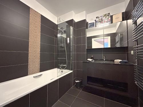 La salle de bains noire est pourvue d'un lavabo et d'une douche. dans l'établissement Phare d'Agay - Zeezicht - 50 meter van het strand, à Saint-Raphaël