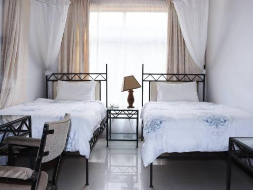 a bedroom with two beds and a window at The Landmark Boutique Hotel in Blantyre