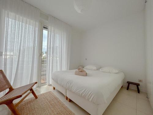 une chambre blanche avec un lit blanc et une fenêtre dans l'établissement Phare d'Agay - Zeezicht - 50 meter van het strand, à Saint-Raphaël