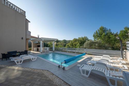 basen z leżakami i zjeżdżalnią w obiekcie 8-bedroom Villa Bianca with Sea View and Pool Table w mieście Premantura