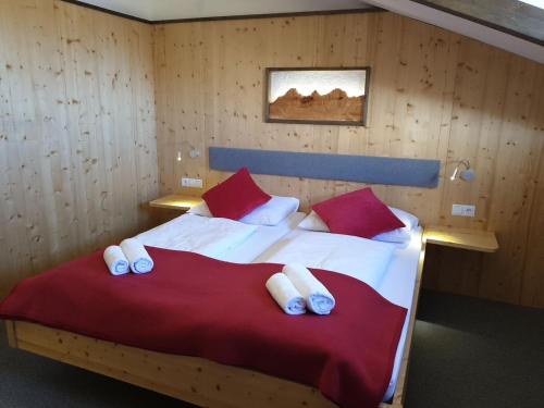 a bedroom with a bed with red and white pillows at Berghotel Türlwand in Ramsau am Dachstein