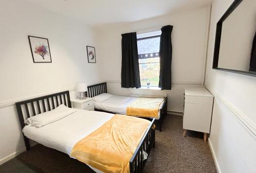 a bedroom with two beds and a window at Bath YMCA Hostel in Bath