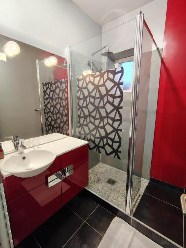 La salle de bains est pourvue d'un lavabo rouge et d'une douche. dans l'établissement Chambre Nérondes Le Lion d'Or, à Nérondes