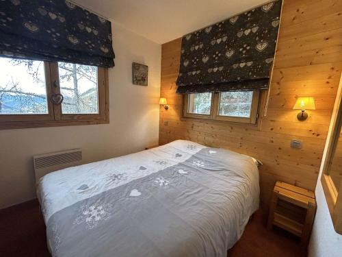 a bedroom with a bed and two windows at Appartement pour 6, centre Méribel, proche commerces et pistes, piscine l'été - FR-1-180-303 in Méribel