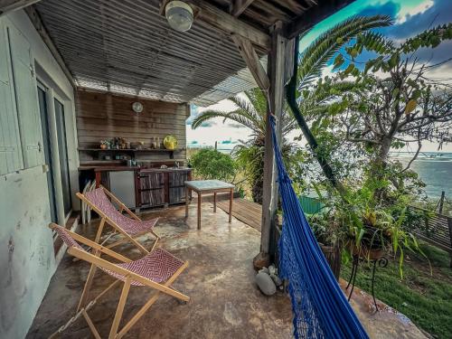 a porch with chairs and a table on a balcony at KazaChatGwadloop in Vieux-Habitants