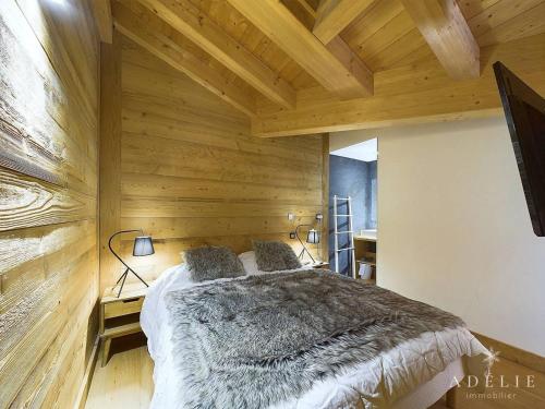 - une chambre avec un grand lit dans un mur en bois dans l'établissement Luxueux Appartement 4* Alpin, 5 Pièces, 4 Ch, Proche Pistes, Parking, WiFi - FR-1-398-549, à La Rosière