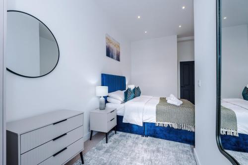 a bedroom with two beds and a mirror at Stylish 1-Bedroom Getaway in Sale in Sale