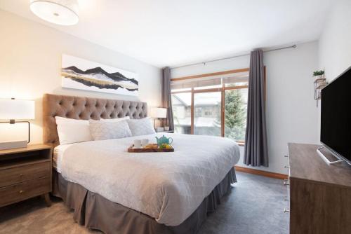 ein Schlafzimmer mit einem großen Bett und einem Fernseher in der Unterkunft Northstar Whistler Village Resort in Whistler