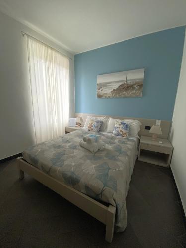 a bedroom with a large bed with a blue wall at Pensione Sorriso in Vernazza