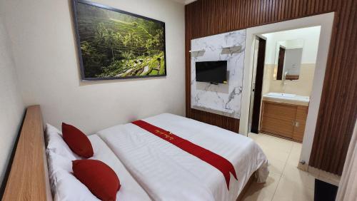 a hotel room with a bed and a bathroom at Puri Rama Guest House Denpasar Bali in Kerobokan