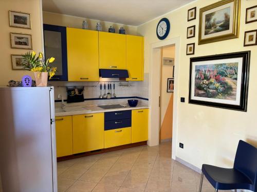 a kitchen with yellow cabinets and a refrigerator at Villa Atlante in Bibione