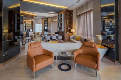 a hotel lobby with two chairs and a table at AC Hotel by Marriott Guadalajara Expo in Guadalajara