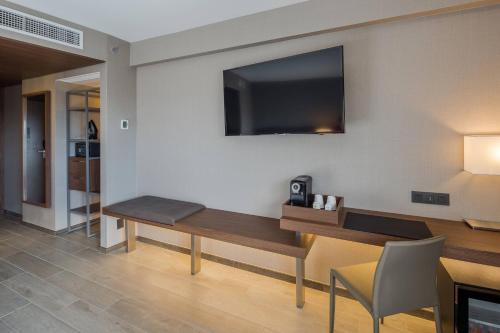 a room with a desk with a tv on the wall at AC Hotel by Marriott Guadalajara Expo in Guadalajara