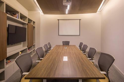 a conference room with a wooden table and chairs at AC Hotel by Marriott Guadalajara Expo in Guadalajara