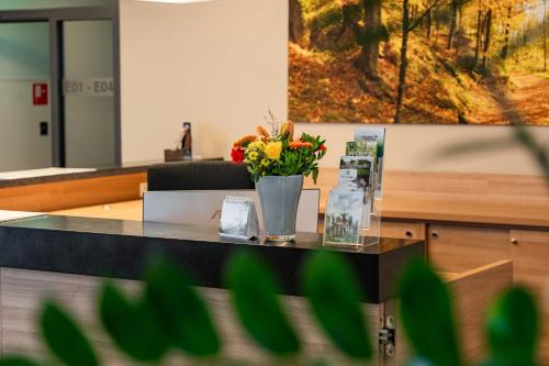 a desk with a vase of flowers on it at Schatz.Kammer Burg Kreuzen in Bad Kreuzen