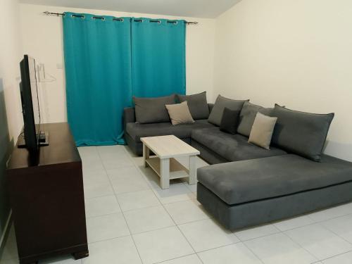 ein Wohnzimmer mit Sofa und Tisch in der Unterkunft Two bedroom holidays apartment, walking distance to the beach and Harbour in Paphos
