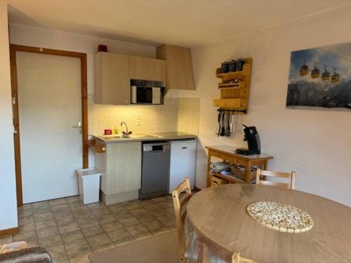 une cuisine avec une table et une petite cuisine avec une table et une table dans l'établissement 3 pièces skis aux pieds avec balcon à Saint-Jean-d'Aulps - FR-1-573-80, à Saint-Jean-dʼAulps