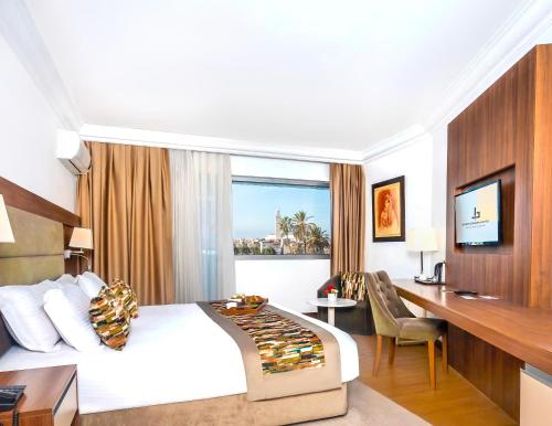 a hotel room with a bed and a desk at Kenzi Basma in Casablanca