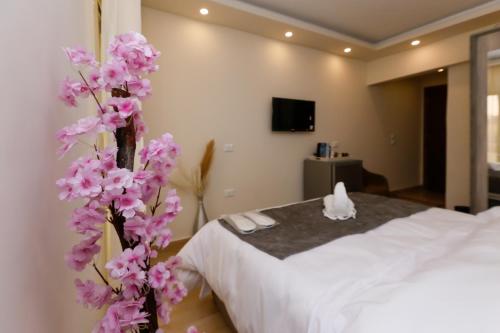 une chambre d'hôtel avec un lit et un arbre à fleurs dans l'établissement Pyramids Art View Inn, au Caire