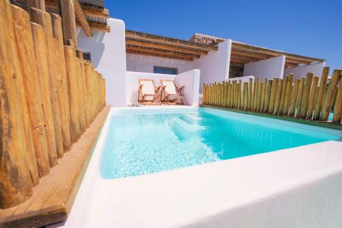 a swimming pool in a house with a wooden fence at Aegean Hospitality in Mýkonos City