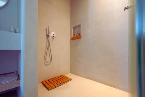 a small bathroom with a shower and a wooden bench at Aegean Hospitality in Mýkonos City