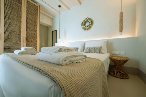 a bedroom with a bed with towels on it at Aegean Hospitality in Mýkonos City