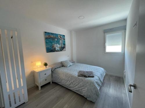a bedroom with a bed and a nightstand and a window at Apartamento n3, a 10 min del aeropuerto in San Fernando de Henares