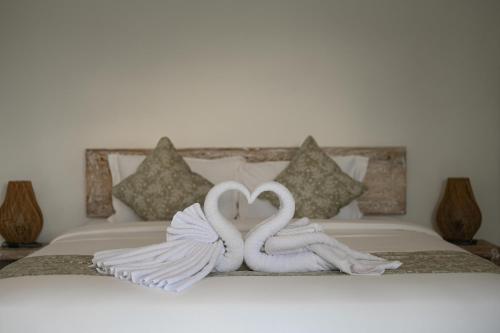 two swans made to look like hearts sitting on a bed at Maganda Villa in Tabanan