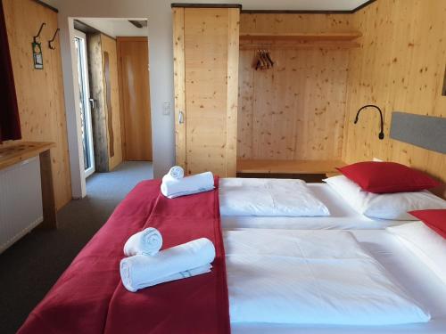 two beds in a hotel room with towels on them at Berghotel Türlwand in Ramsau am Dachstein